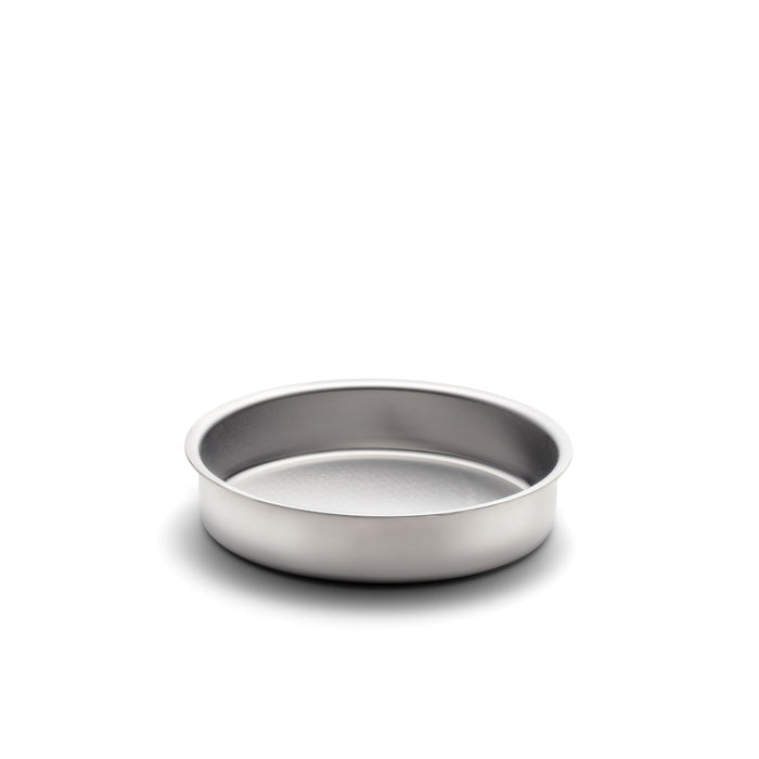 Three quarter view of 9 inch round cake pan showcasing stainless steel construction and no handles on white background