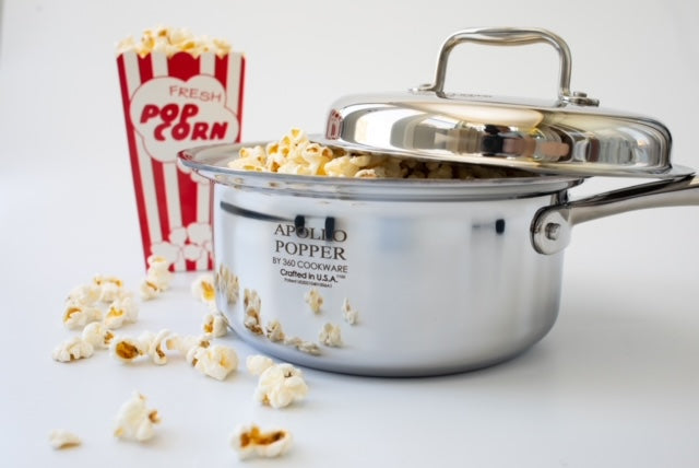 Stainless-steel APOLLO POPPER BY 360 COOKWARE with lid, spilled popcorn and striped box reading FRESH POP CORN