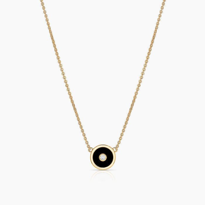 A gold-plated necklace with a black enamel and cubic zirconia disc charm on a cable chain.