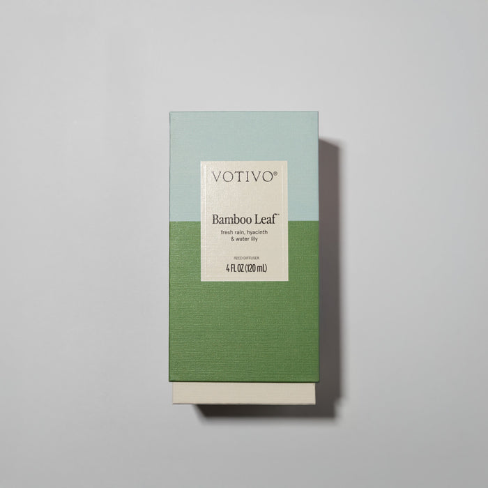 A box of the Votivo Bamboo Leaf Reed Diffuser with a green and light blue color block design, fiber reeds, and a label showing the product name and size: 4 fl oz (120 mL).