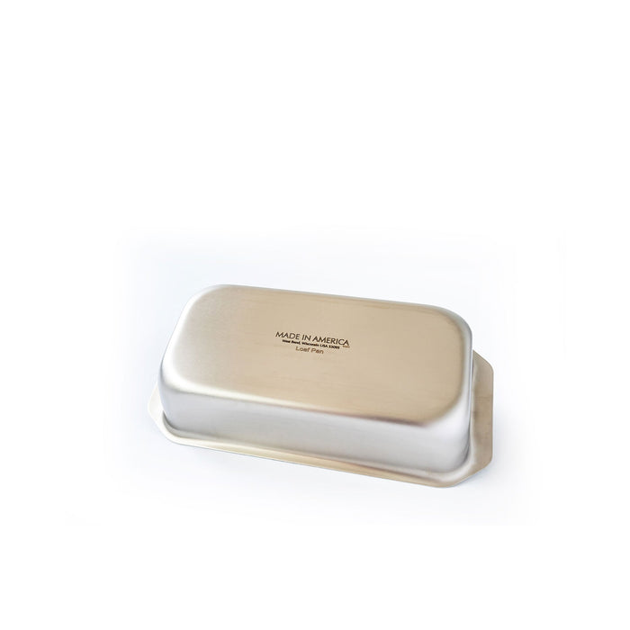 Bottom view of stainless steel loaf pan with tab handles showing Made in America stamp on white background