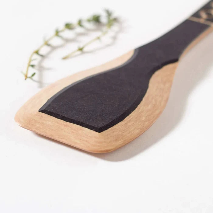 Close-up of Frank Lloyd Wright Paddle showing black silicone paddle and wooden handle on white background with thyme sprig