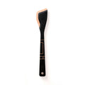 Front view of Frank Lloyd Wright saute tool showing black finish with copper Art Deco accents and angled spatula head on white background