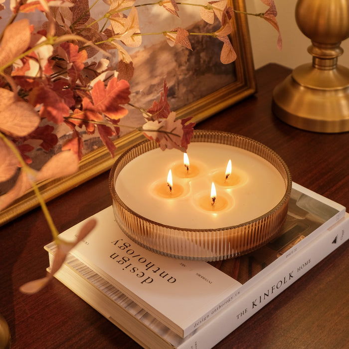 4 Wick Spiced Chai Multiwick Candle sitting on stack of books on console table