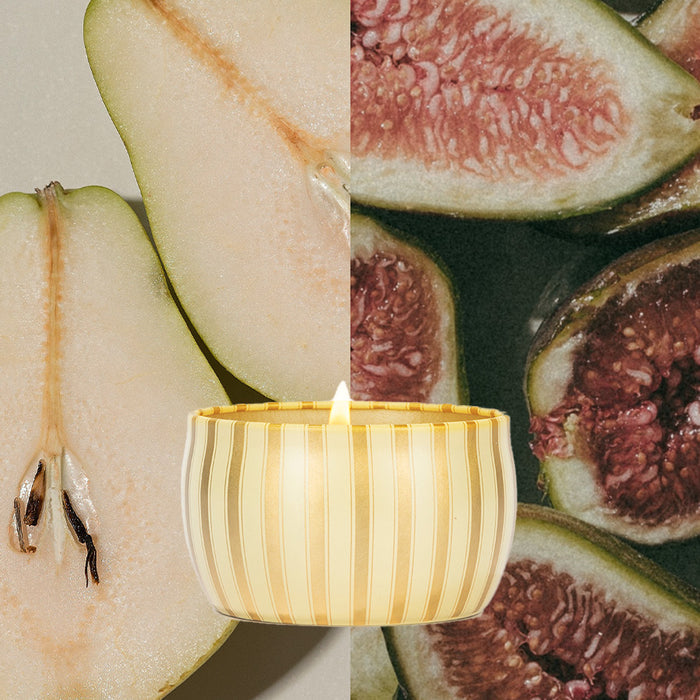 Votivo’s Gilded Pear Holiday Tin Candle, crafted with luxe soy blend wax, burns in the foreground atop a split background showing a close-up of gilded pear on the left and sliced figs on the right.