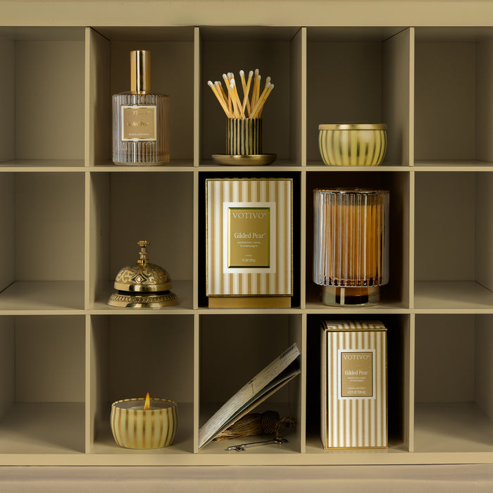 A styled cubby featuring Gilded Pear candles & room spray and decorative accents