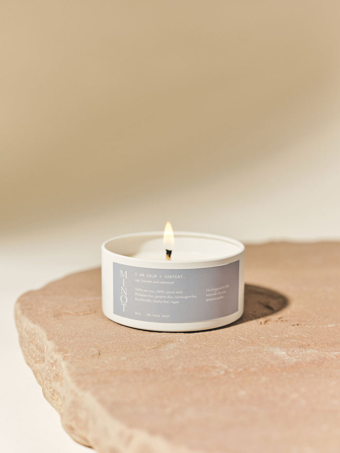 The I Am Calm + Content affirmation candle in tin features calming lavender, sage and cedar scents