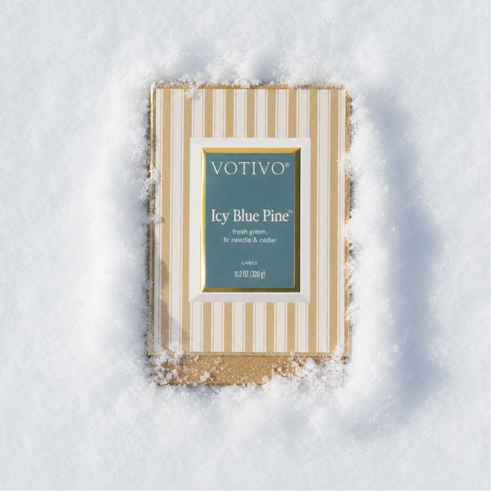 An Icy Blue Pine Boxed Candle sitting in fluffy, white snow