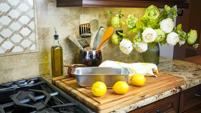 Angled view of Loaf Pan with Tab Handles showing stainless steel finish and wide tab handles on a wooden cutting board