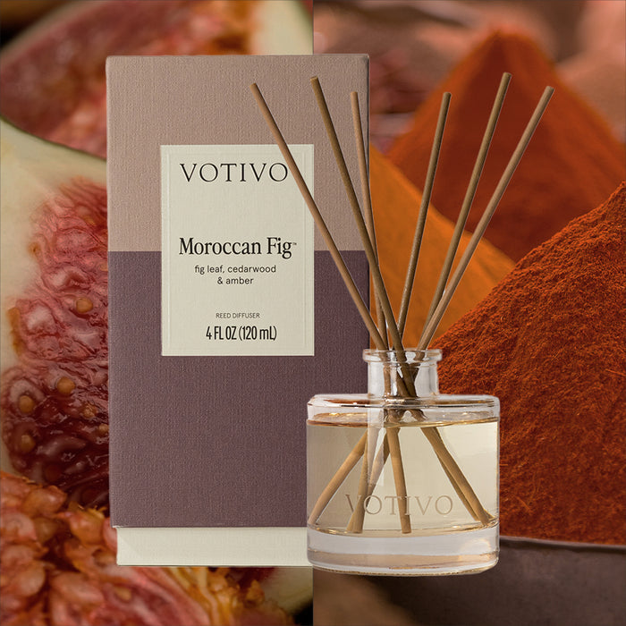 The Votivo Moroccan Fig Reed Diffuser features a glass bottle and fragrance sticks in a boxed set, providing continuous scent, displayed before fresh figs and reddish-brown powder.