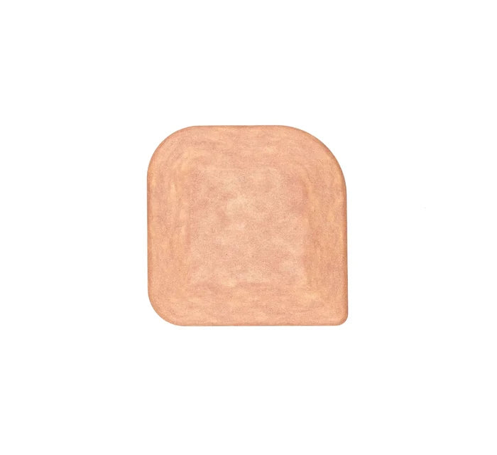 Top view of natural wood pan scraper showing rounded-square shape and beveled scraping edge on white background