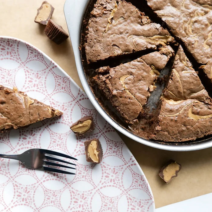 Top view of Personal Pizza Pan showing peanut butter swirl brownies and tab handle with patterned plate and fork