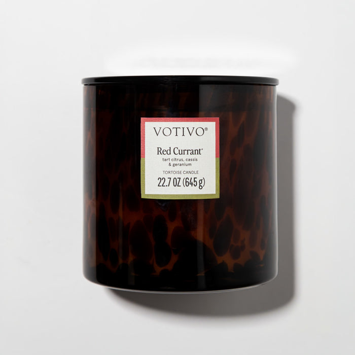 The Votivo Red Currant Tortoise Candle features a 22.7 oz soy blend with tart citrus, cassis, geranium, and red currant notes in a brown tortoise jar, displayed on a plain white background.