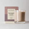 A Votivo Saint Germain Lavender 10 oz. Signature Candle in a clear glass holder is shown with its box—this premium soy blend candle features soothing lavender, chamomile, and tonka bean notes.