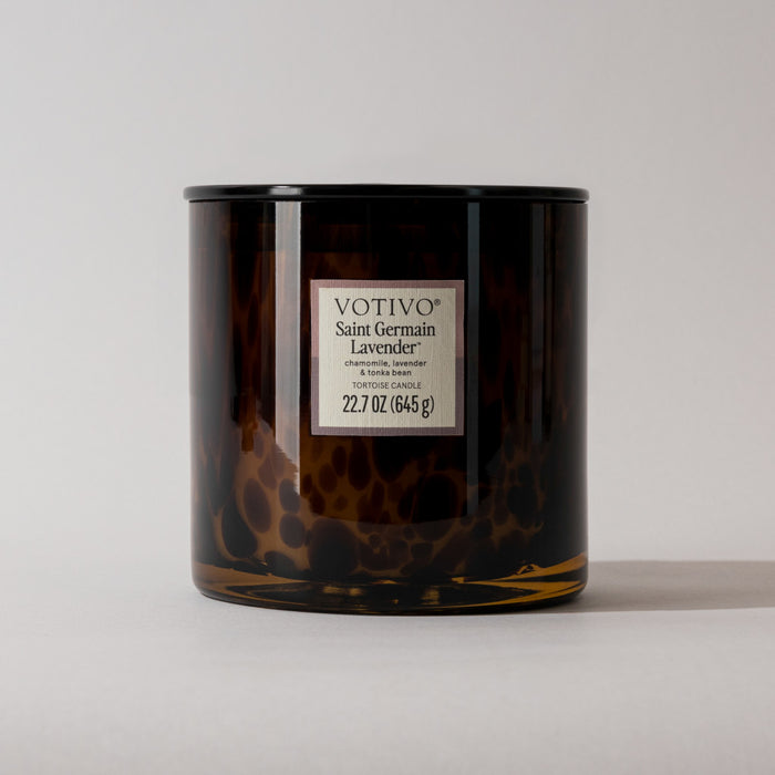 A brown tortoiseshell-patterned Votivo Saint Germain Lavender Tortoise Candle (22.7 oz, soy blend) with a labeled jar is shown on a plain light background.