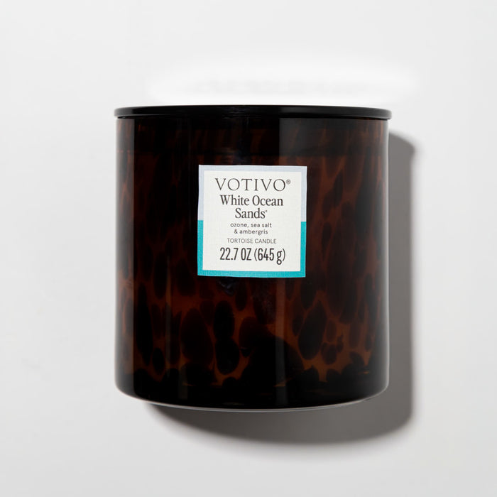 A 22.7 oz (645 g) Votivo White Ocean Sands Tortoise Candle, housed in a dark brown tortoiseshell-patterned jar with a luxurious soy blend, is shown against a white background.